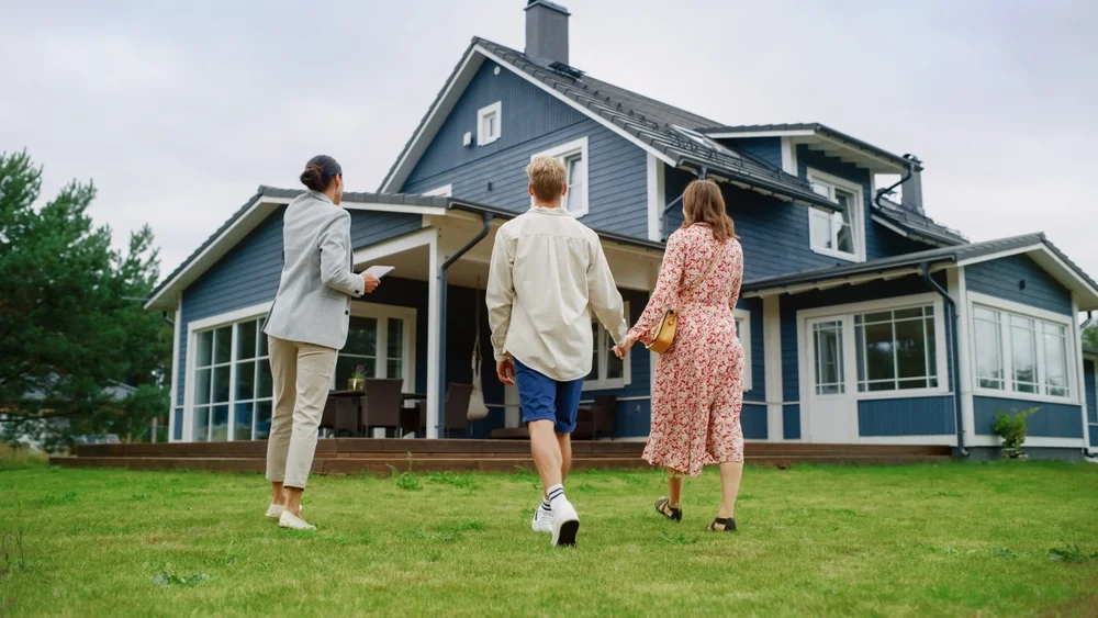 Professional Realtor Showing A Hot Property Location To A Young Couple